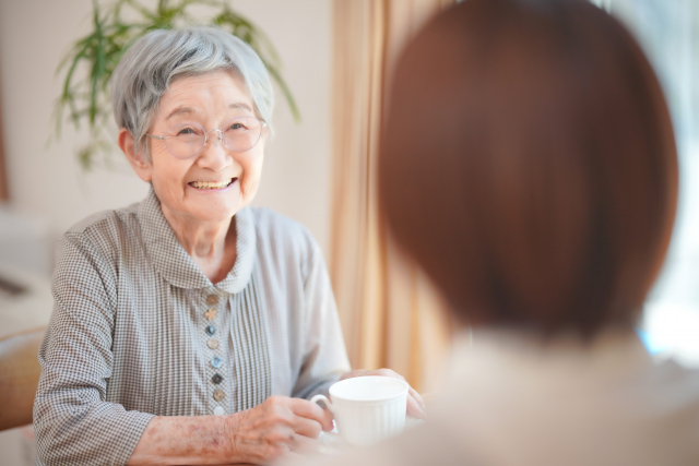 A caregiver sharing warm conversation with a senior client at home